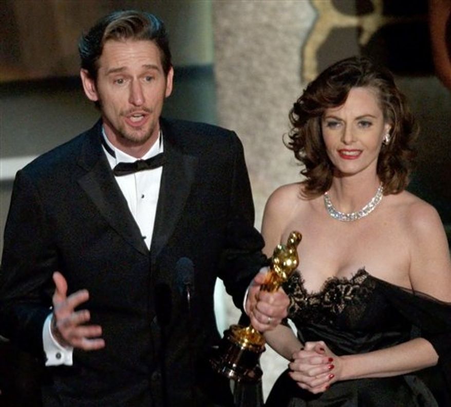 FILE - In a March 24, 2002 file photo, Ray McKinnon, center, and Lisa Blount, accept their Oscars for best live action short film for "The Accountant" during the 74th annual Academy Awards, in Los Angeles. A news release from publicist Steve Rohr has confirmed that Blount, the Arkansas-born actor and Academy Award winning filmmaker has died at age 53. Blount was living in Little Rock with her husband _ actor and director Ray McKinnon. (AP Photo/Kevork Djansezian, File)