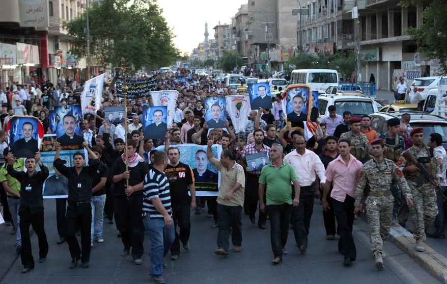 Muslims and Christians chant anti-terrorist slogans during a funeral of slain Christians in Baghdad, Iraq, Tuesday, Nov. 2, 2010. The victims were killed Sunday when gunmen stormed a church during mass and took the entire congregation hostage. (AP Photo/Khalid Mohammed)