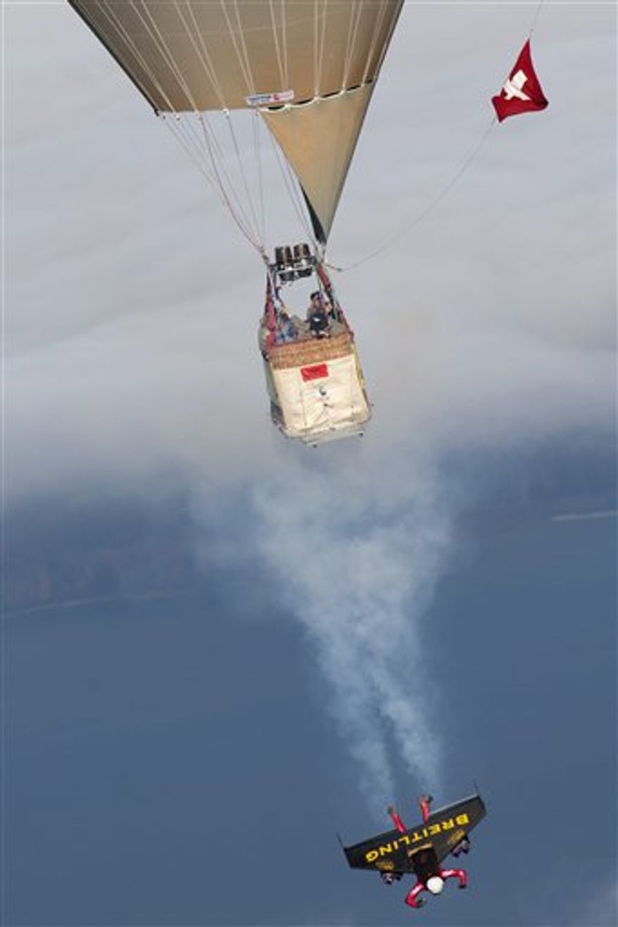 Swiss pilot Yves Rossy, the first man in the world to fly under a jet-fitted wing, stands on a platform of a hot air balloon in Bercher, western Switzerland, Friday, Nov. 5, 2010. Rossy has completed two aerial loops using a custom-made jet-propelled wingsuit after he jumped from the balloon. (AP Photo/Keystone, pool, Laurent Gillieron)