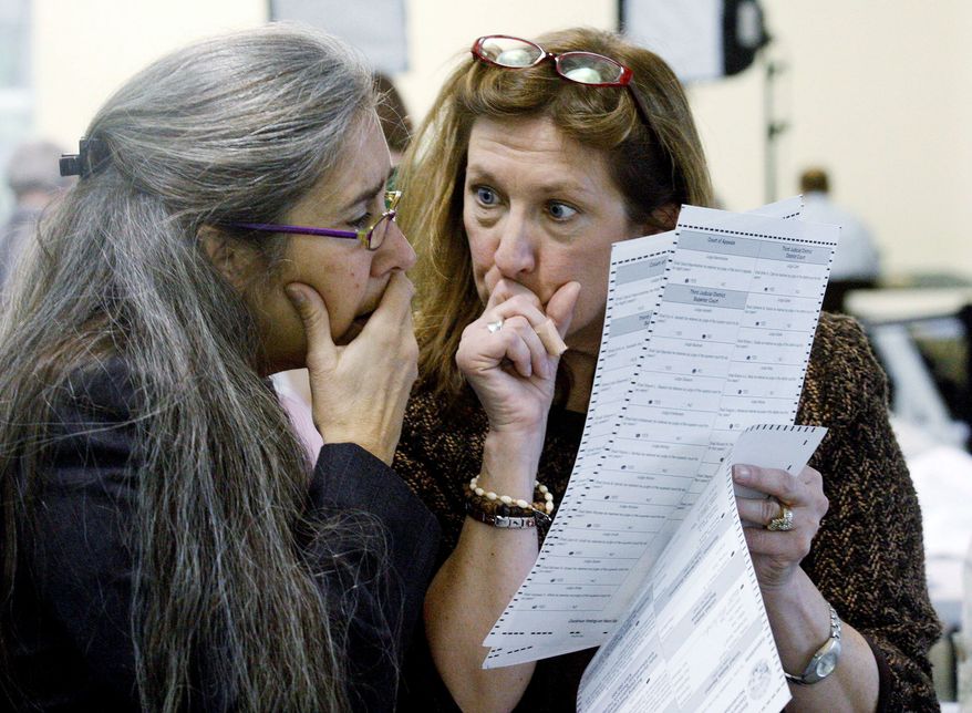 Alaska Elections Division Director Gail Fenumiai (right) and state Assistant Attorney General Sarah Felix examine a ballot Wednesday in Juneau. Republican nominee Joe Miller sued Tuesday to prevent the state from using discretion in determining voter intent on write-in ballots. (Associated Press)