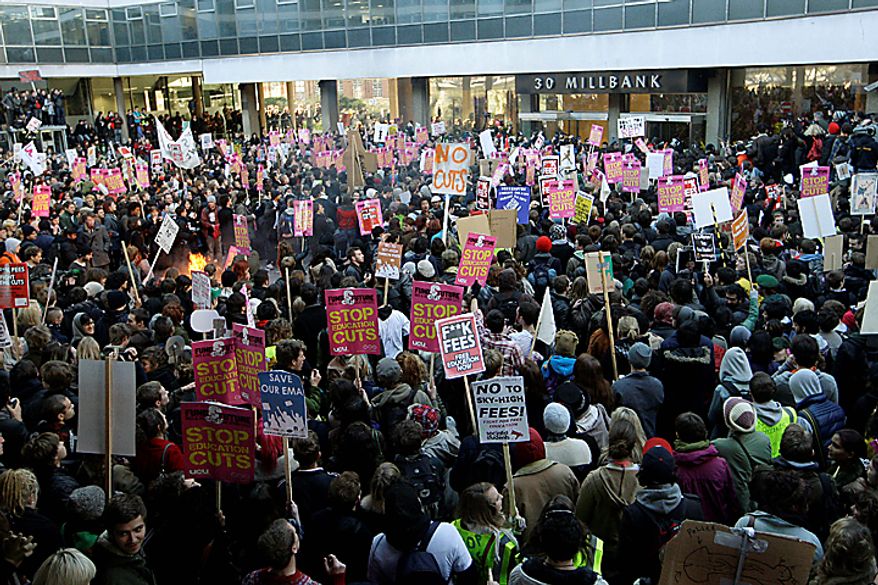Thousands of protesting students gather outside the headquarters of Britain's Conservative Party in London, Wednesday Nav. 10, 2010, in a demonstration against plans to increase tuition fees and cut university funding. Organizers claimed that 50,000 students, lecturers and supporters were demonstrating against plans to raise the cost of studying to 9,000 pounds ($14,000) a year - three times the current rate.(AP Photo/Sang Tan)
