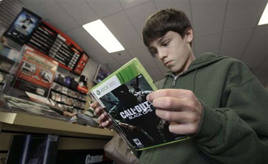 Augustine Sewell, 13, right, and his mother Patricia Sewell look over the new Call of Duty: Black Ops video game they purchased in Sacramento, Calif., Tuesday, Nov. 9, 2010. One of the most anticipated game introductions of the year, Activision's Call of Duty: Black Ops, went on sale at midnight Tuesday. (AP Photo/Rich Pedroncelli)