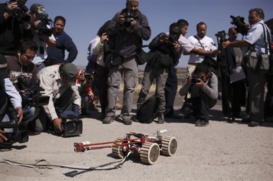 A robot used to explore ruins in Teotihuacan, Mexico, sits on the ground Wednesday, Nov. 10, 2010. The small foot-wide wheeled vehicle, able to record video, entered a 2,000-year-old tunnel found earlier this year under the ruins of the temples of Teotihuacan. (AP Photo/Alexandre Meneghini)