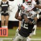 Oakland Raiders wide receiver Jacoby Ford (12) catches a pass over Kansas City Chiefs cornerback Brandon Flowers during the fourth quarter of an NFL football game in Oakland, Calif., Sunday, Nov. 7, 2010. Oakland won 23-20 in overtime. (AP Photo/Paul Sakuma)