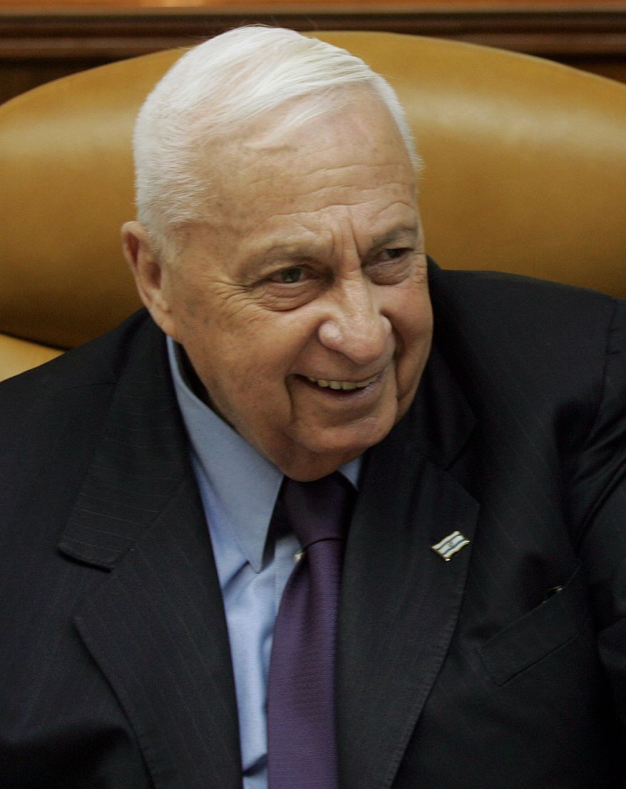 ** FILE ** Then-Israeli Prime Minister Ariel Sharon smiles as he talks to journalists on Sunday, Dec. 18, 2005, before the weekly Cabinet meeting in Jerusalem. (AP Photo/ Emilio Morenatti)