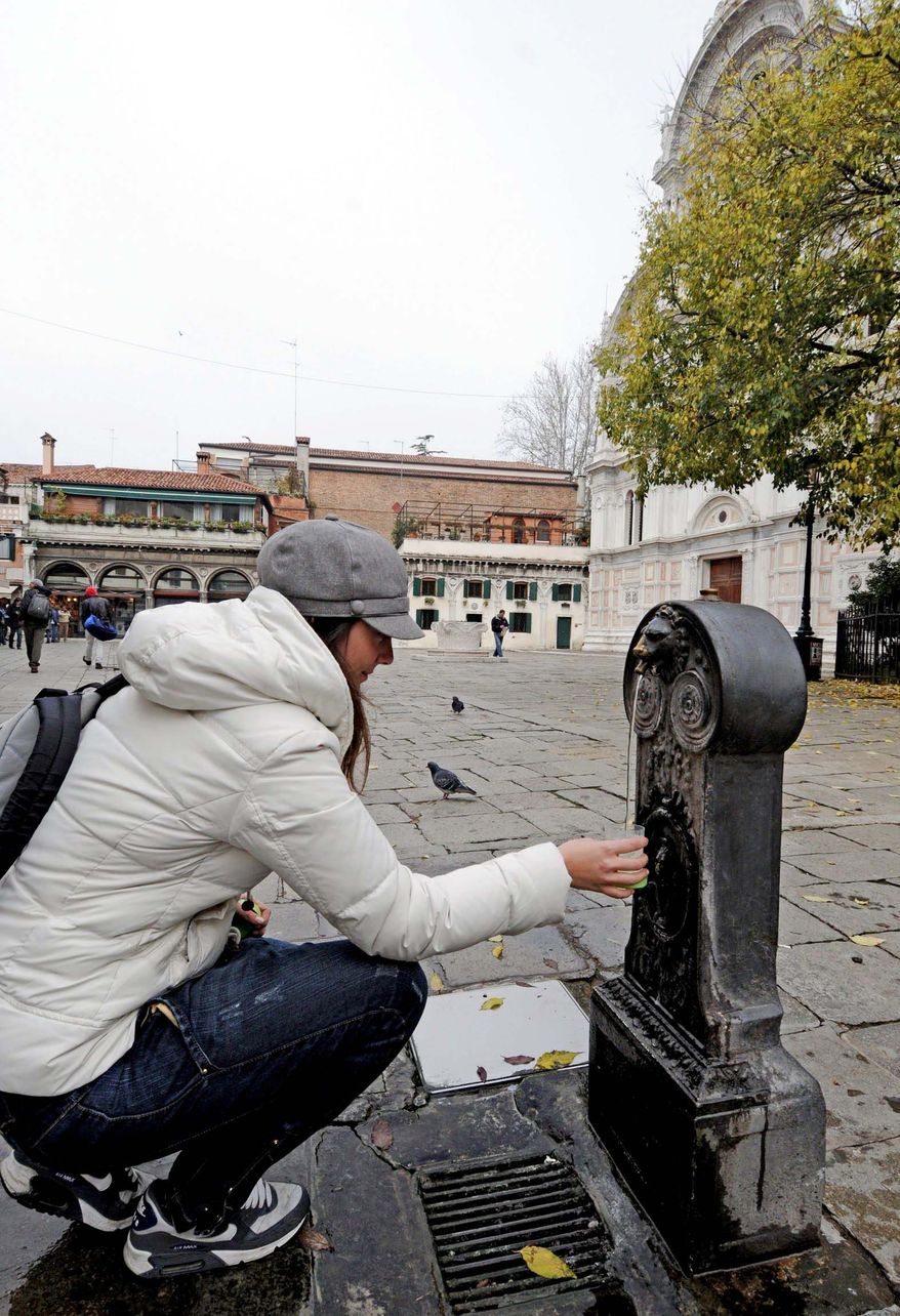 A tourist fills a glass from a water fountain Thursday in Venice. One reason why Venice would want to reduce the volume of plastic trash that accumulates in the Lagoon City is that trash removal in a city of canals, bridges and stairs is a monumental task.