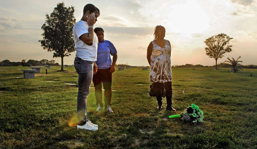 J.M. EDDINS JR./THE WASHINGTON TIMES
NOT FORGOTTEN: LaVonne Abney (left), with her mother, Ruth Wheeler (right), and LaVonne&#39;s niece, Leshawn Wheeler, 15, visit the Landover, Md., grave of Chicquelo Abney on the first anniversary of his death.