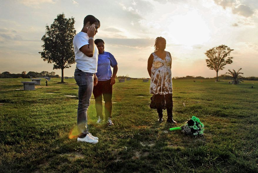 J.M. EDDINS JR./THE WASHINGTON TIMES
NOT FORGOTTEN: LaVonne Abney (left), with her mother, Ruth Wheeler (right), and LaVonne's niece, Leshawn Wheeler, 15, visit the Landover, Md., grave of Chicquelo Abney on the first anniversary of his death.