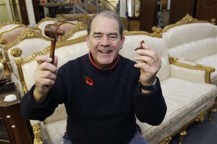 Auctioneer Peter Bainbridge holds up the Bainbridges auction catalogue showing the vase that he auctioned Thursday, in London, Friday, Nov. 12, 2010. The 18th century Chinese porcelain vase, discovered when a house was cleared out, was sold for 43 million pounds ($69.3 million). The amount was thought to be among the highest ever paid for any Chinese artwork sold at auction. (AP Photo/Kirsty Wigglesworth)