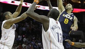 Utah Jazz&#39;s Deron Williams (8) puts up the winning shot over Charlotte Bobcats&#39; Boris Diaw, left, and Nazr Mohammed (13) during the second half of an NBA basketball game on Saturday, Nov. 13, 2010, in Charlotte, N.C. Utah defeated Charlotte 96-95. (AP Photo/Rick Havner)