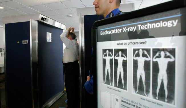 In this photo taken Sept. 1, 2010, Transportation Security Administration employee Anthony Brock, left, demonstrates a new full-body scanner at San Diego&#x27;s Lindbergh Field, with TSA employee Andres Lozano in San Diego.  (AP Photo/San Diego Union Tribune, Eduardo Contreras)