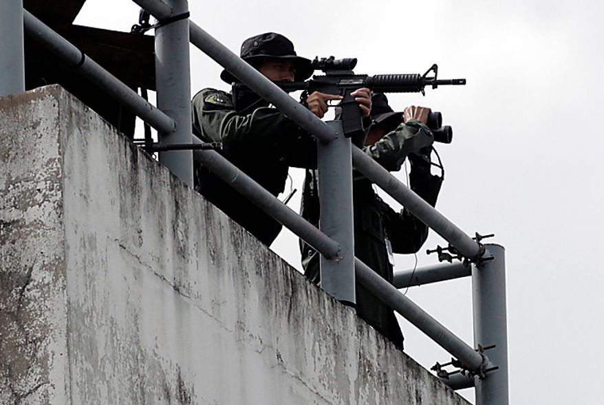 Armed commando officers stand by as the motorcade of accused Russian arms dealer arrived at Don Muang Airport in Bangkok on Tuesday Nov. 16, 2010. The Thai government extradited accused Russian arms trafficker Viktor Bout to the United States on Tuesday to face terrorism charges, rejecting heavy pressure from Moscow for him to be freed. (AP Phoot/Sakchai Lalit)