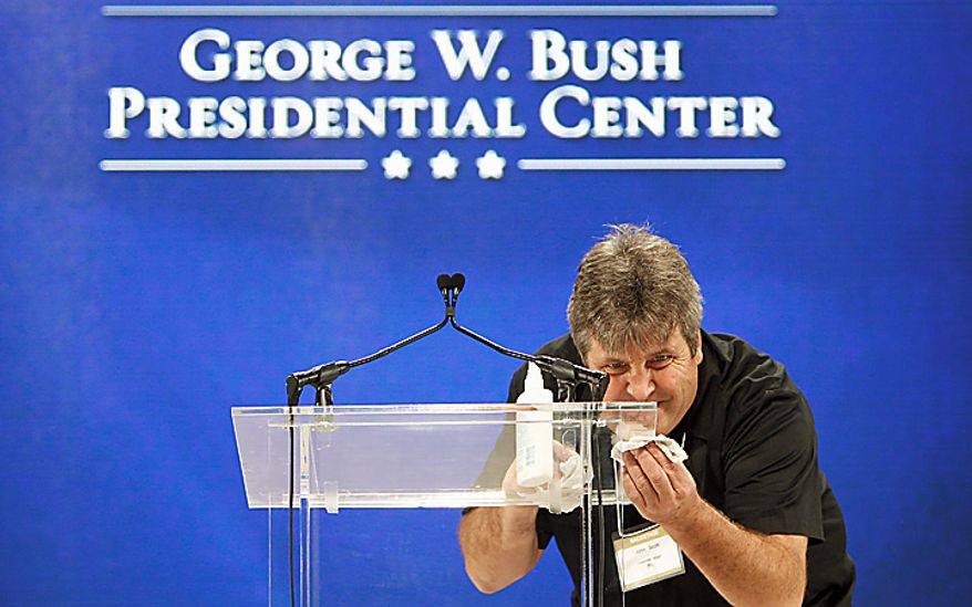 John Scott cleans the podium on the stage in preparation for the groundbreaking ceremony for the George W. Bush Presidential Center in Dallas, Tuesday, Nov. 16, 2010. (AP Photo/LM Otero)