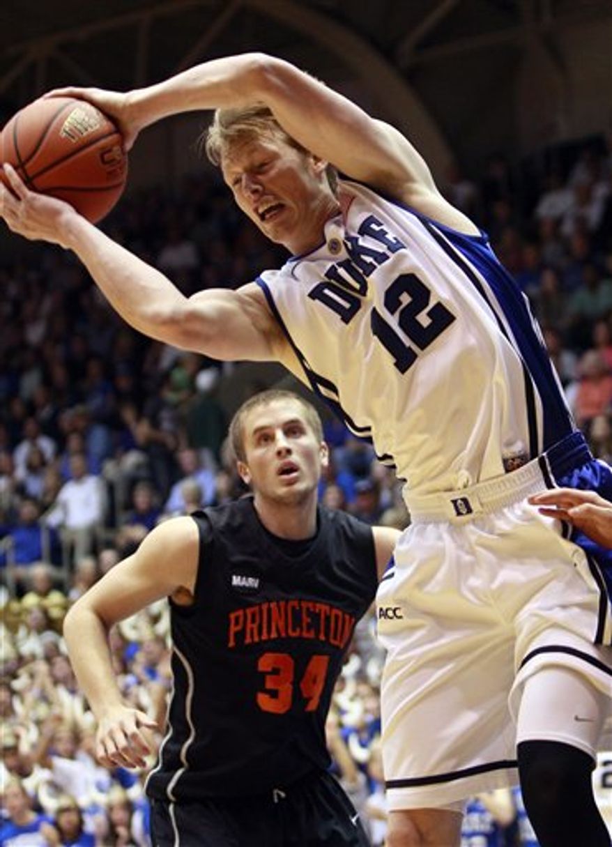 Duke's Kyle Singler (12) pulls down a rebound over Princeton's Ian Hummer (34) during the first half of an NCAA college basketball game in Durham, N.C., Sunday, Nov. 14, 2010. (AP Photo/Gerry Broome)