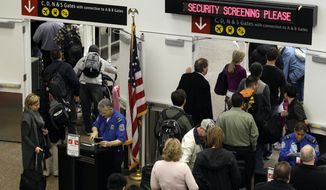 ** FILE ** TSA agents check passenger identification at a security gate on Friday, Nov. 19, 2010, at Seattle-Tacoma International Airport in Seattle. (AP Photo/Ted S. Warren)
