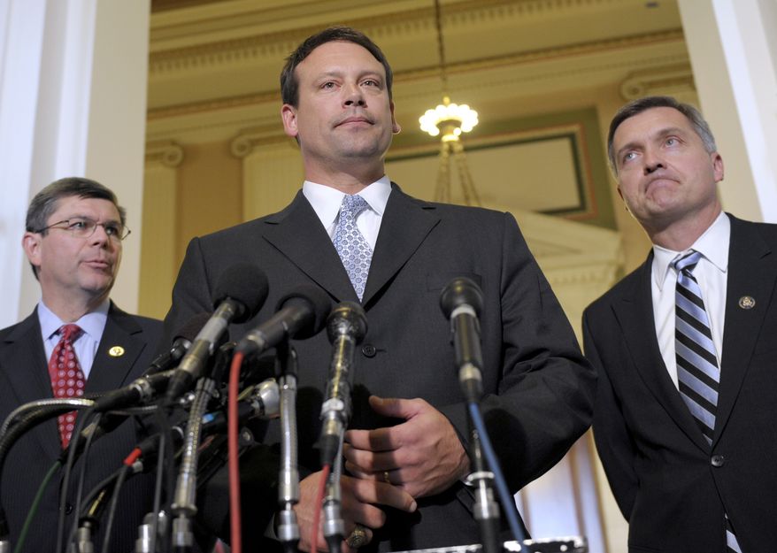 **FILE** Rep. Heath Shuler, North Carolina Democrat (center), accompanied by Reps. Mike Ross, Arkansas Democrat (left), and Jim Matheson, Utah Democrat, speaks to reporters on Capitol Hill on Nov. 17. (Associated Press)