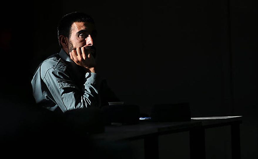 In this Nov. 7, 2010 photo, a new Afghan police recruit attends a literary class at Central Training Center on the outskirts of Kabul, Afghanistan. According to the NATO training mission, only 11 percent of the enlisted personnel in the army and police can read and write, compared to 35 percent for non-commissioned officers and 93 for the officer corps. About 74 percent of the population is illiterate, but the percentage in the security forces tends to be higher since fewer educated Afghans are willing to sign up. (AP Photo/Altaf Qadri)