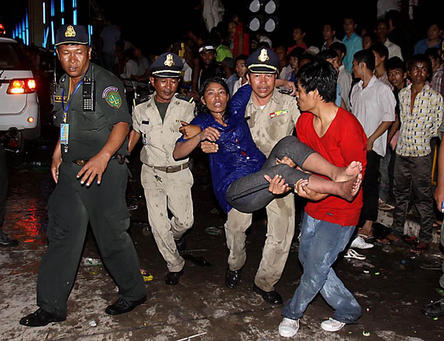 An injured Cambodian is carried by police and other visitors after a stampede onto a bridge at an accident site during the last day of celebrations of the water festival in Phnom Penh, Cambodia, Monday, Nov. 22, 2010. Thousands of people celebrating a water festival on a small island in a Cambodian river stampeded Monday evening, killing many people, a hospital official said. Hundreds more were hurt as the crowd panicked and pushed over the bridge to the mainland. (AP Photo/Heng Sinith)