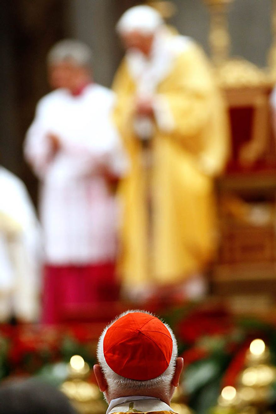 German Cardinal Reinhard Marx, back to camera, attends a mass celebrated by Pope Benedict XVI, seen in background, in St. Peter's Basilica, Vatican, Sunday, Nov. 21, 2010. The Pontiff formally created 24 new cardinals on Saturday amid cheers in St. Peter's Basilica, bringing a mostly Italian group into the elite club that will eventually elect his successor. (AP Photo/Pier Paolo Cito)
