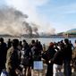 BRINK OF WAR: South Koreans watch smoke rising from South Korea&#39;s Yeonpyeong Island near the border with North Korea on Tuesday. The North fired artillery barrages onto the island. South Korea returned fire and launched fighter jets. (Associated Press)