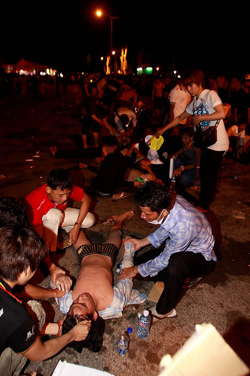 An injured Cambodian is helped by other visitors after a stampede onto a bridge at an accident site during the last day of celebrations of the water festival in Phnom Penh, Cambodia, Monday, Nov. 22, 2010. Thousands of people celebrating a water festival on a small island in a Cambodian river stampeded Monday evening, killing many people, a hospital official said. Hundreds more were hurt as the crowd panicked and pushed over the bridge to the mainland. (AP Photo/Heng Sinith)