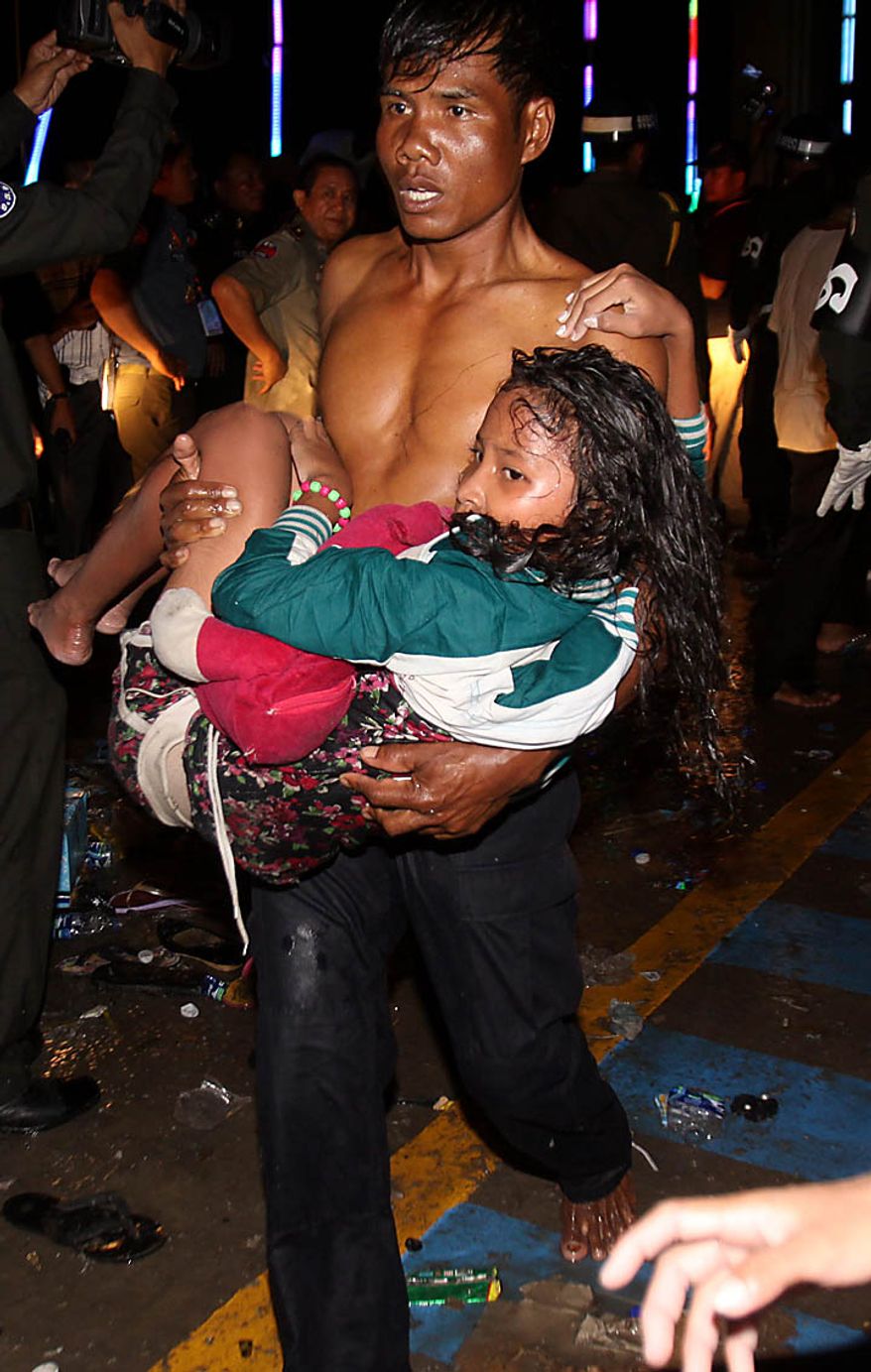 An injured Cambodian is carried by a another visitor after a stampede onto a bridge at an accident site during the last day of celebrations of the water festival in Phnom Penh, Cambodia, Monday, Nov. 22, 2010. Thousands of people celebrating a water festival on a small island in a Cambodian river stampeded Monday evening, killing many people, a hospital official said. Hundreds more were hurt as the crowd panicked and pushed over the bridge to the mainland. (AP Photo/Heng Sinith)