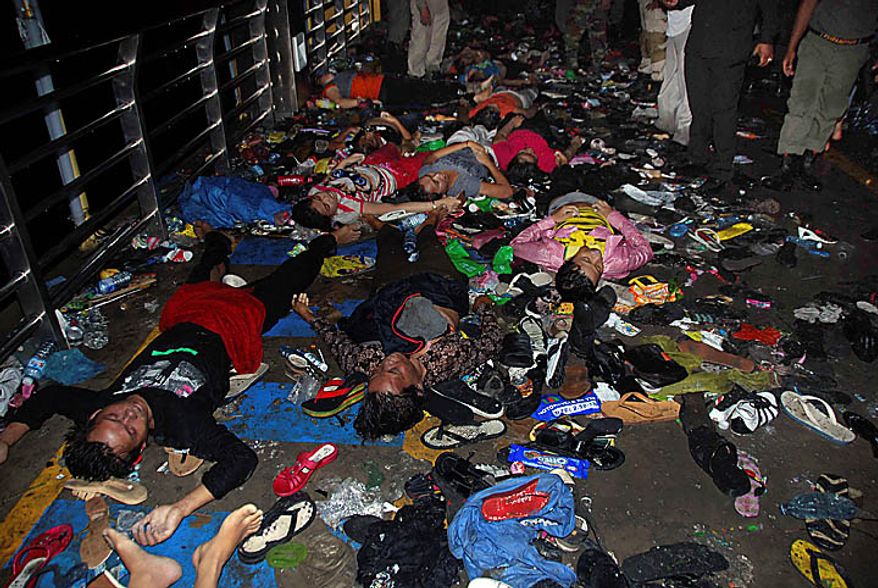 The bodies and belongings of Cambodians, who died in a stampede, lie on a bridge in Phnom Penh, Cambodia, Tuesday, Nov. 23, 2010. Thousands of people stampeded during a festival in the Cambodian capital Monday night, leaving more than 330 dead and hundreds injured in what the prime minister called the country's biggest tragedy since the 1970s reign of terror by the Khmer Rouge. (AP Photo/Philip Heijmans)