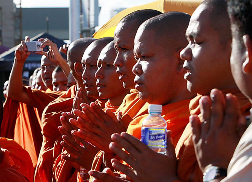 Cambodian Buddhist monks pray for victims near the site where people stampeded during Monday's water festival in Phnom Penh, Cambodia, Tuesday, Nov. 23, 2010. Thousands of people stampeded during the festival late Monday, leaving over three hundred dead and scores injured in what Prime Minister Hun Sen called the country's biggest tragedy since the 1970s reign of terror by the Khmer Rouge. (AP Photo/Heng Sinith)