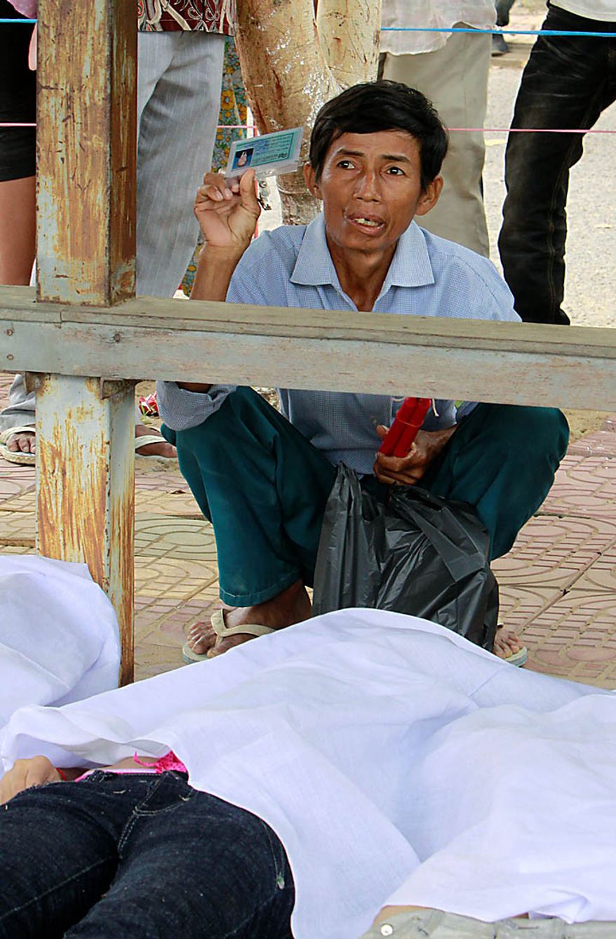 A Cambodian relative of a stampede victim shows the dead's identification card at Preah Kossamak Hospital in Phnom Penh, Cambodia, Tuesday, Nov. 23, 2010. Thousands of people stampeded during a festival in the Cambodian capital, leaving over three hundred dead and scores injured in what the prime minister called the country's biggest tragedy since the 1970s reign of terror by the Khmer Rouge. (AP Photo/Heng Sinith)