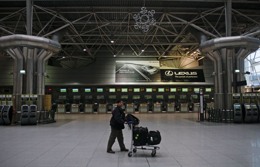 A passenger flying to the U.S. pushes his trolley in a nearly deserted check-in hall of Lisbon's international airport Wednesday, Nov. 24, 2010, during the usually busy early morning. Dozens of flights were canceled Wednesday in Portugal due to a general strike protesting the government's austerity measures aimed at controlling the country's current financial crisis. (AP Photo/Francisco Seco)