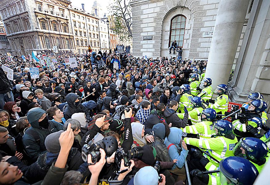 Student protesters clash with police during a demonstration against an increase in university tuition fees, in Westminster, central London, Wednesday Nov. 24, 2010. Several thousand British students protested Wednesday against government plans to triple tuition fees, two weeks after a similar demonstration sparked a small riot. (AP Photo/Anthony Devlin/PA)