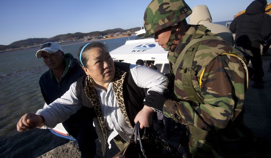 A South Korean marine helps a woman disembark from a ferry ship Thursday as she returns to her home on Yeonpyeong Island. South Korea&#39;s president vowed to boost troops on the island targeted by a North Korean artillery barrage, while the North stridently warned of additional attacks if the South carries out any &quot;reckless military provocations.&quot; (Associated Press)