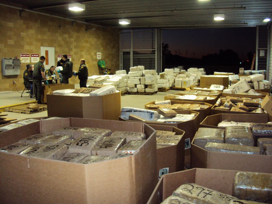 In this Nov. 25, 2010, photo released by U.S. Immigration and Customs Enforcement (ICE), packages of seized marijuana are examined by officials in Murrieta, Calif., after a cross-border tunnel between Tijuana, Mexico and San Diego was discovered. (AP Photo/U.S. Immigration and Customs Enforcement)