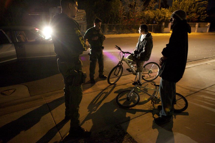 While patrolling in Cathedral City, Calif., police Officer Miguel Torres (left) and Mr. LaBella (second from left) stop teenagers who were riding bicycles without lights.