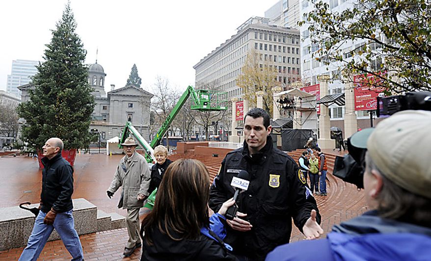 Portland police sergeant Pete Simpson is interviewed in front of the Christmas tree in Pioneer square on Saturday Nov. 27, 2010 in Portland, Ore., the morning after a car bomb plot was foiled during the annual tree lighting ceremony. Federal agents in a sting operation arrested a Somali-born teenager just as he tried blowing up a van he believed was loaded with explosives at the crowded event, authorities said. (AP Photo/Greg Wahl-Stephens)