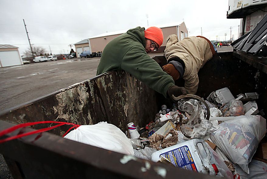 Volunteers David Patterson, of Archbold, Ohio, left, and Matthew Poorman, of Swanton, Ohio, search a dumpster behind Hutches Towing as the search for 9-year-old Andrew, 7-year-old Alexander and 5-year-old Tanner Skelton continues in Holiday City, Ohio on Tuesday, Nov. 30, 2010. Authorities "do not anticipate a positive outcome" in the search for three Michigan brothers who have been missing since their father's attempted suicide, a police chief said Tuesday. (AP Photo/Detroit Free Press, Andre J. Jackson)
