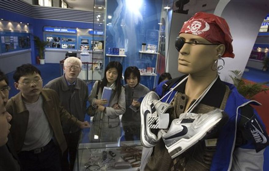 FILE - In this April 17, 2006 file photo, visitors walk past a mannequin set up to show how individuals attempt to get past customs, smuggling counterfeit products in violation of intellectual property rights law during an exhibition in Beijing. China's government announced a new crackdown Tuesday, Nov. 30, 2010 on rampant illegal copying of products from software to music that is adding to tensions with Washington and other governments over trade and currency complaints. (AP Photo/Ng Han Guan, File)