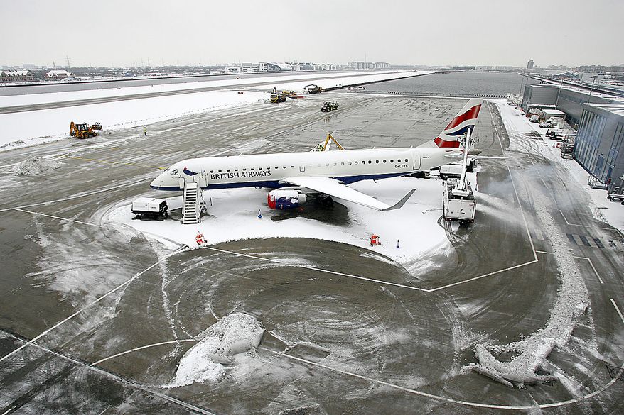 A British Airways plane is seen parked as staff clear snow on the runways to reopen the airport at the London City Airport in London, Thursday, Dec. 2, 2010. More heavy snow caused havoc across Britain on Thursday, keeping Gatwick airport closed for a second day, disrupting rail services and leaving travelers stranded. Commuters struggled to get to work as Britain's worst early winter weather in almost two decades showed no sign of easing its icy grip.(AP Photo/Akira Suemori)