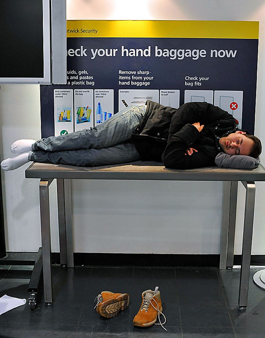 A passenger at London's Gatwick Airport finds somewhere to rest as flights are canceled for the remainder of the day, because of bad weather Wednesday Dec. 1, 2010. Large areas of Britain were brought to a halt Wednesday as freezing weather bought air and rail travel schedules to a halt. (AP Photo / Clive Gee, PA)