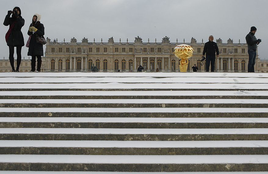 Snow covers the steps leading to the Chateau de Versaille, as Japanese tourists take pictures in Versailles, west of Paris, Thursday, Dec. 2, 2010. Heavy snow and subzero temperatures swept across Europe, killing at least eight homeless people in Poland, closing major airports in Britain and Switzerland, and causing delays to rail and road traffic across the continent.(AP Photo/Michel Euler)