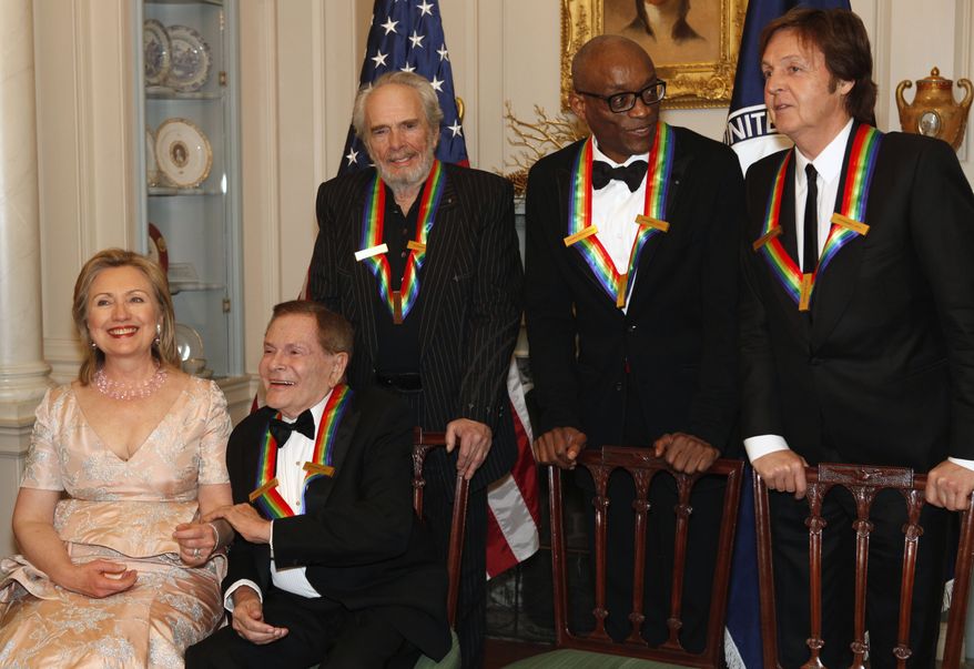 Secretary of State Hillary Rodham Clinton talks with Kennedy Center honorees (from second from left) Jerry Herman, Merle Haggard, Bill T. Jones and Paul McCartney while waiting for Oprah Whitney to arrive for a group photo after a dinner at the State Department in Washington on Saturday, Dec. 4, 2010. (AP Photo/Jacquelyn Martin)