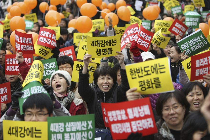 Anti-government protesters shout slogans and hold signs during a rally against the South Korean government's policies and financial plans on Sunday, Dec. 5, 2010, in Seoul. (AP Photo/Wally Santana)
