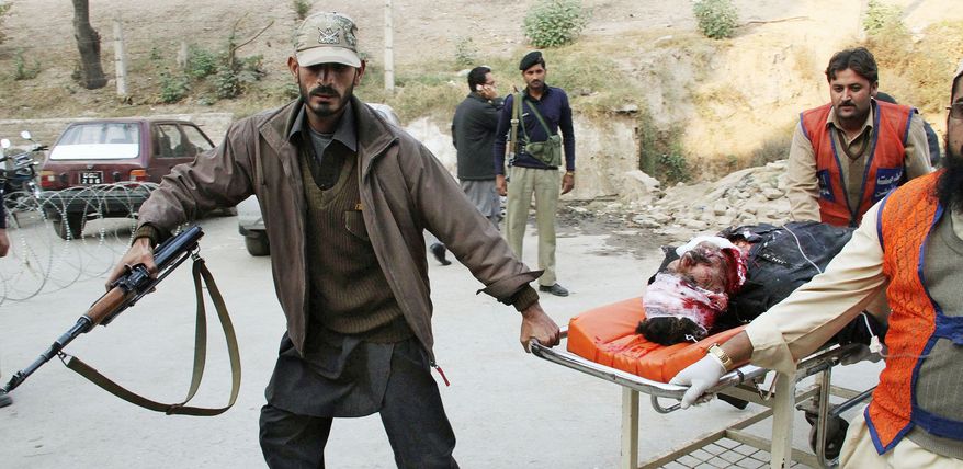 Pakistani volunteers rush an injured person into a local hospital in Peshawar on Monday. A pair of suicide bombers disguised as policemen killed as many as 50 people and wounded an estimated 100 in an attack targeting a tribal meeting called to discuss the formation of an anti-Taliban militia in Pakistani tribal area of Mohmand. (Associated Press)