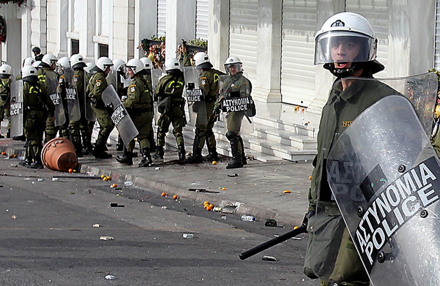 A riot policeman reacts during clashes with youths in Athens on Monday, Dec. 6, 2010. Youths hurled rocks and oranges at a government building in central Athens during a student protest to mark two years since the fatal police shooting of a teenage boy that sparked Greece's worst riots in decades. Police closed roads and deployed several thousand officers around the city but maintained a minimal presence at the site where some 1,500 students gathered outside Athens University's main buildings. (AP Photo/Thanassis Stavrakis)