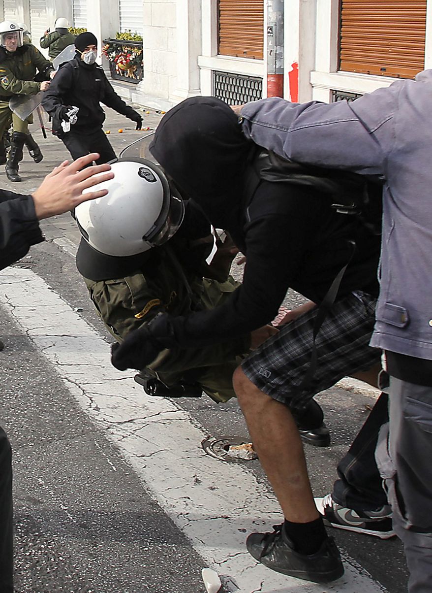 A youth attacks a riot policeman during a rally in Athens on Monday, Dec. 6, 2010. Youths hurled rocks and oranges at a government building in central Athens during a student protest to mark two years since the fatal police shooting of a teenage boy that sparked Greece's worst riots in decades. Police closed roads and deployed several thousand officers around the city but maintained a minimal presence at the site where some 1,500 students gathered outside Athens University's main buildings. (AP Photo/Thanassis Stavrakis)