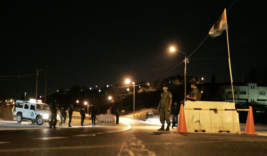 Palestinian security forces man a checkpoint in Nablus on the West Bank in late November. The U.S.-trained forces coordinate with Israeli troops, but some of them wonder if cooperation is sustainable and really helps their statehood goal. (Associated Press)