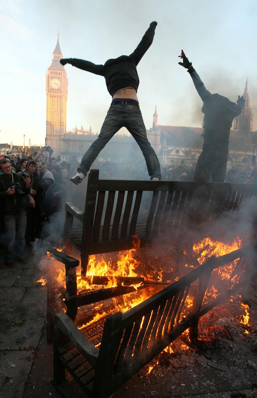 British police medics carry an injured protester away, as thousands of students demonstrate outside the Houses of Parliament in London Thursday Dec. 9, 2010, during a protest against an increase in university tuition fees(AP Photo/Sang Tan)