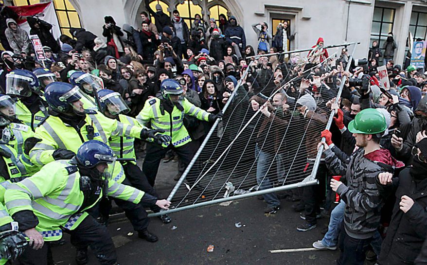 Protesters and police officers clash during a demonstration against an increase in tuition fees, on the edge of Parliament Square in London, Thursday, Dec. 9, 2010. Police clashed with protesters marching to London's Parliament Square as lawmakers debated a controversial plan to triple university tuition fees in England. (AP Photo/Matt Dunham)