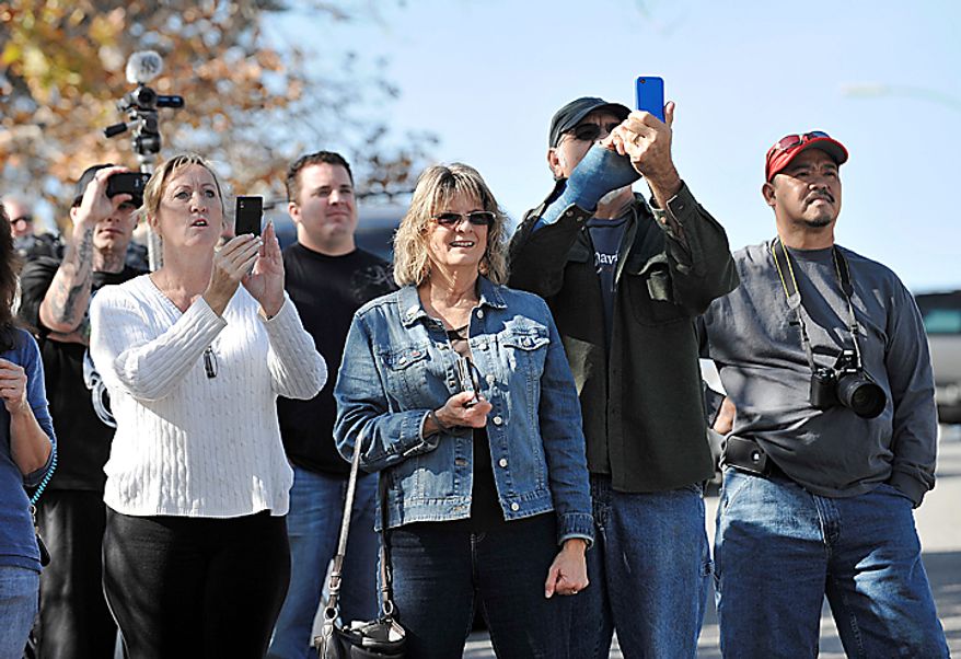 Neighbors watch the controlled burn of a home in Escondido, Calif., on Thursday, Dec. 9, 2010 that was so packed with homemade explosives that authorities claim they had no choice but to burn it to the ground. The house was rented by an out-of-work software consultant who allegedly assembled an astonishing quantity of bomb-making materials that included chemicals used by Middle Eastern suicide bombers.(AP Photo/Denis Poroy)