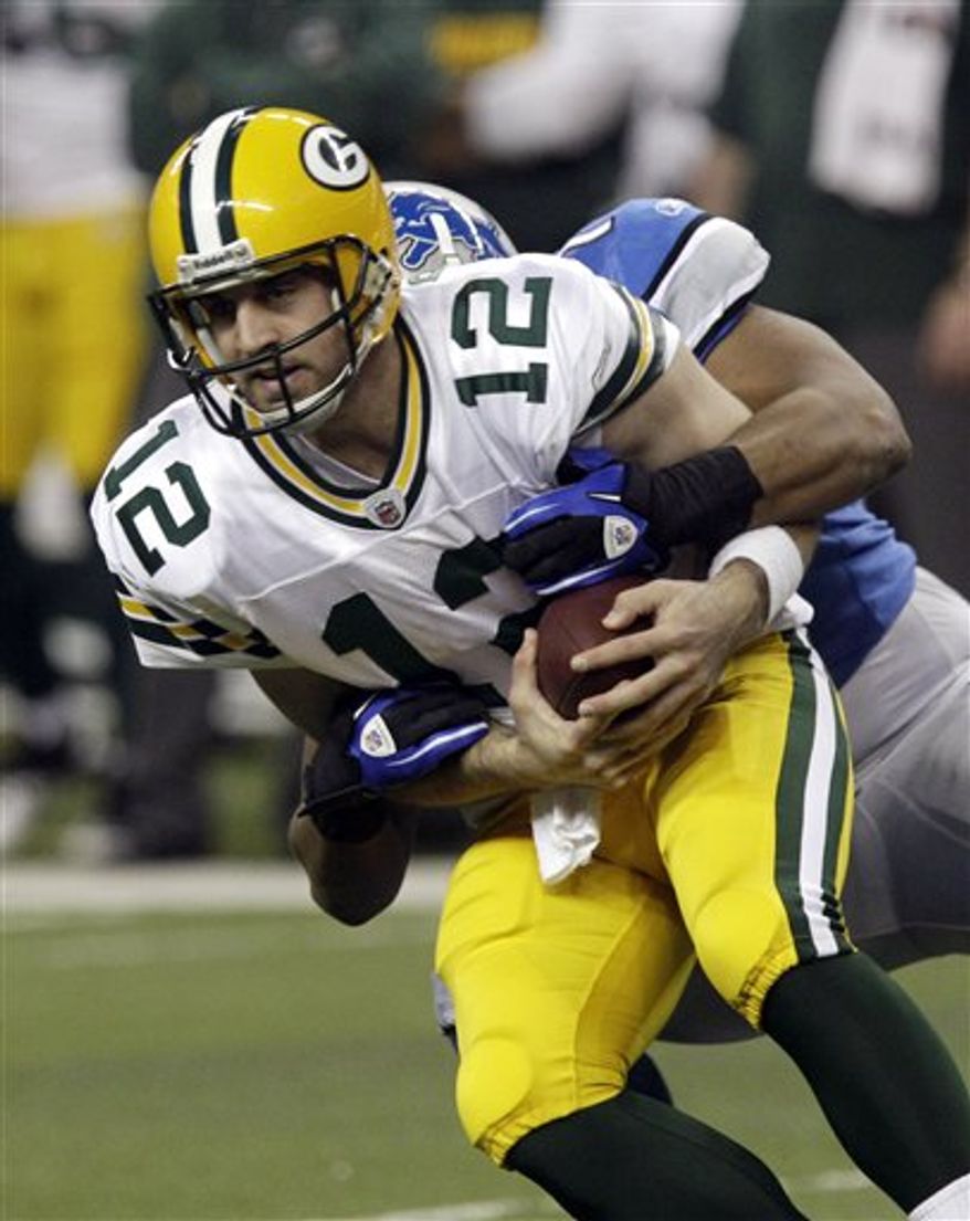 Green Bay Packers quarterback Aaron Rodgers (12) gets tackled by Detroit Lions linebacker Landon Johnson (55) and is knocked out of the game in the second quarter of the NFL football game in Detroit, Sunday, Dec. 12, 2010. (AP Photo/Rick Osentoski)